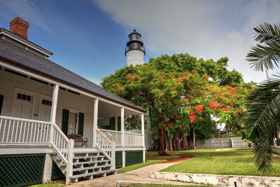 Key west lighthouse with a poinciana tree out front overlooks old town key west in monroe county