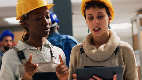 Portrait of smiling friends using digital tablet