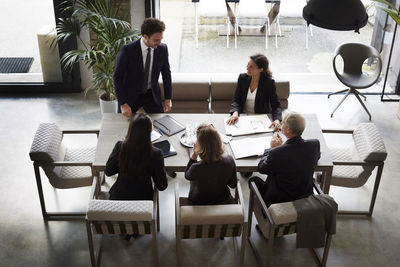 High angle view of financial advisors with businessman and businesswoman planning at office during meeting