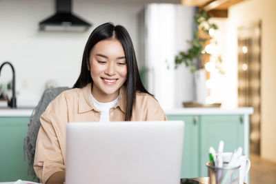 Young woman using laptop at home