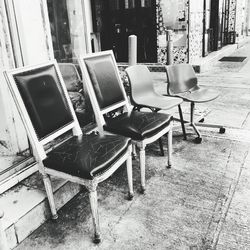 Empty chairs and tables at sidewalk cafe