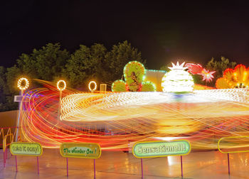 Close-up of illuminated carousel against clear sky at night