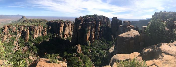 Scenic view of rock formations on landscape against sky