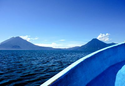 View of calm blue sea against mountain range