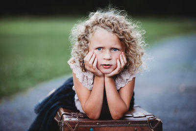 Portrait of cute girl sitting outdoors