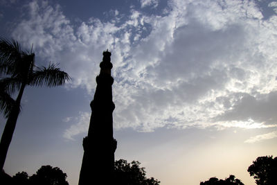 Low angle view of silhouette statue against cloudy sky