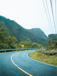 Road by mountain against clear sky