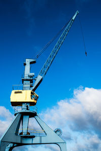 Low angle view of crane against sky