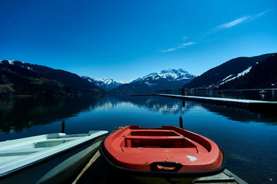 Scenic view of lake by mountains against blue sky