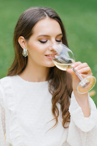 Beautiful young woman with glass of wine on green background person