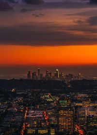 Illuminated cityscape against sky during sunset