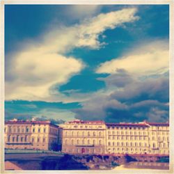 Buildings against cloudy sky