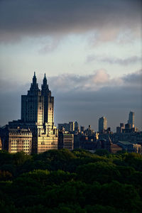 Buildings in city against cloudy sky