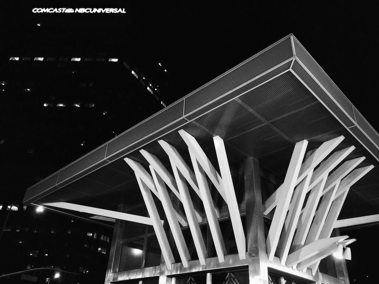 night, low angle view, architecture, illuminated, built structure, building exterior, sky, no people, outdoors, city, clear sky, dark, building, lighting equipment, copy space, architectural feature, arts culture and entertainment, modern, light - natural phenomenon, famous place