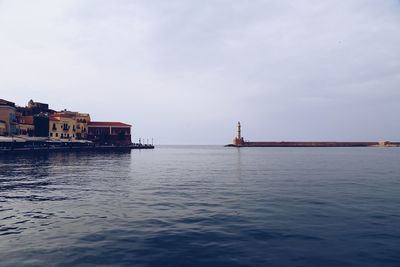 Scenic view of sea by buildings against sky