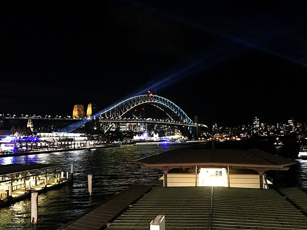 ILLUMINATED BRIDGE OVER RIVER IN CITY