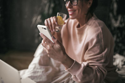 Midsection of woman using mobile phone