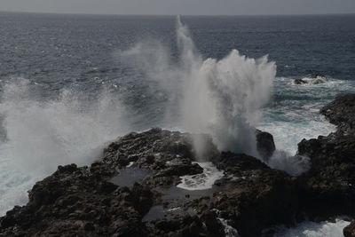 Waves splashing on rocks against sea