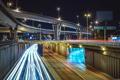 Light trails on bridge in city at night
