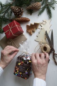 Cropped hands of person packing sweet food at table