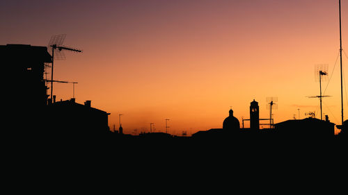 Silhouette buildings against sky during sunset