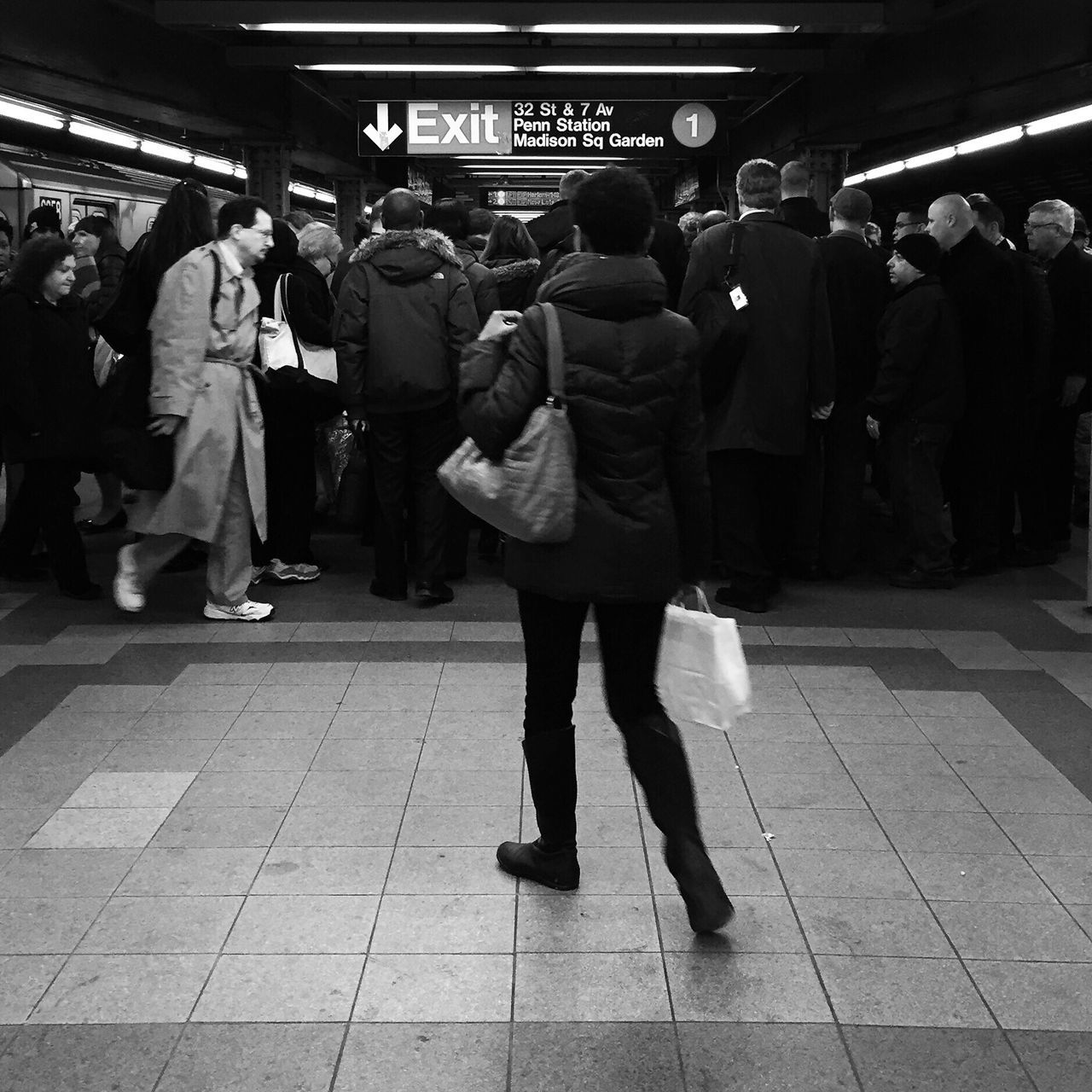 person, men, lifestyles, walking, large group of people, indoors, text, city life, railroad station, leisure activity, full length, rear view, standing, non-western script, public transportation, casual clothing, travel, communication, tiled floor