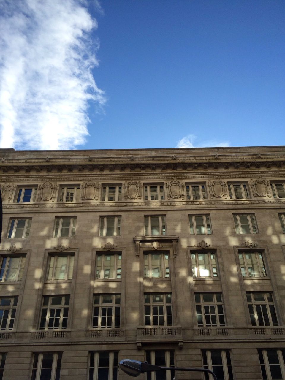 architecture, building exterior, built structure, low angle view, window, sky, building, blue, residential building, city, residential structure, day, outdoors, no people, facade, glass - material, high section, clear sky, cloud, sunlight