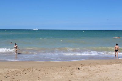 People on beach against sky