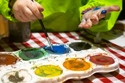 Midsection of person holding colorful toys on table