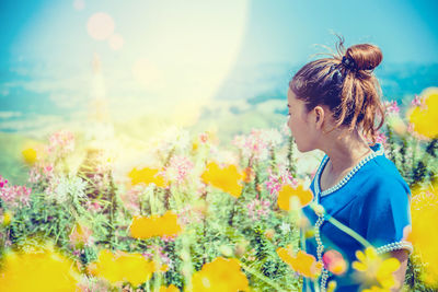 Woman standing on yellow flowering plants