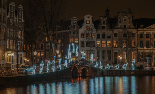 Illuminated decorations on bridge over river in residential district