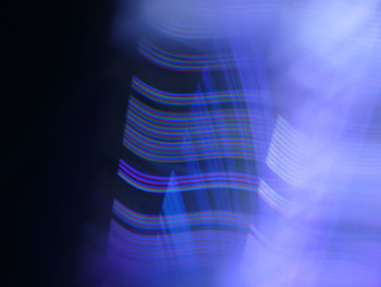 Close-up of illuminated light over blue background