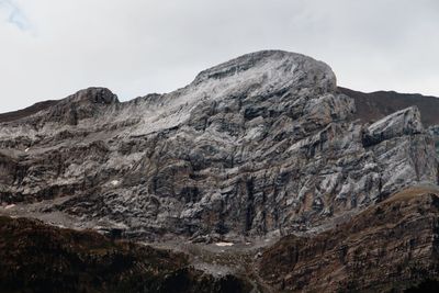 Low angle view of rocky mountains against sky