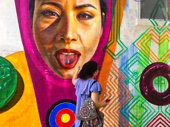 Portrait of boy standing against multi colored background