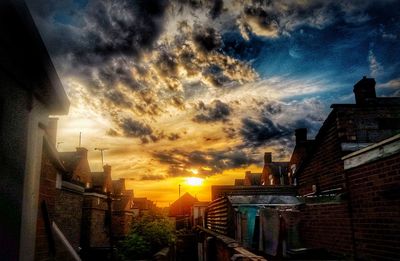 View of buildings against cloudy sky at sunset