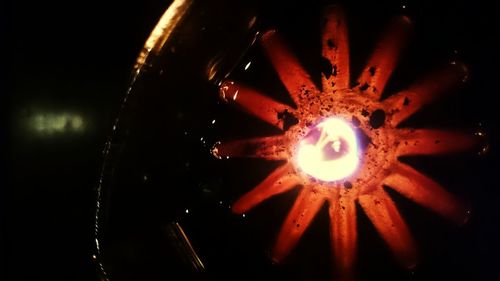 Close-up of illuminated lamp against dark sky