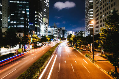 Light trails on street amidst buildings in city