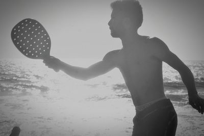 Close-up of silhouette hand on beach