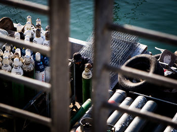 High angle view of man holding cylinder by lake