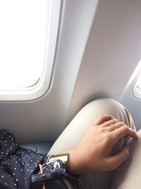 Cropped image of woman sitting by window in airplane