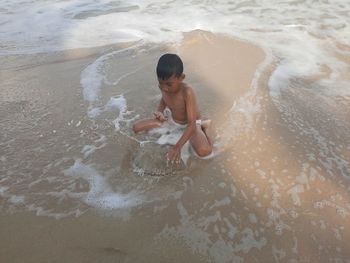 High angle view of shirtless boy on beach