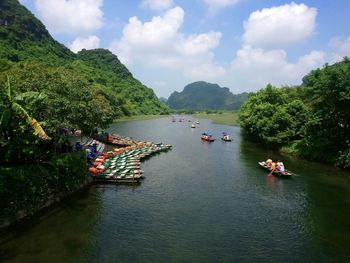 People on boat in river against sky