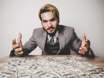 Portrait of young businessman with paper currency at table