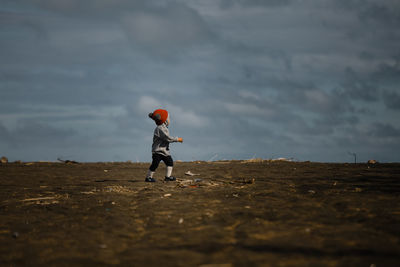 Rear view of woman walking on field