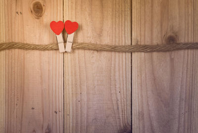 Close-up of heart shape with clothespins on wood