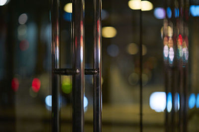 Close-up of metal door handle on glass door