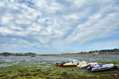 Boats moored on sea against sky