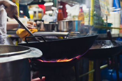 Low angle view of wok on gas stove at outdoors street food stall