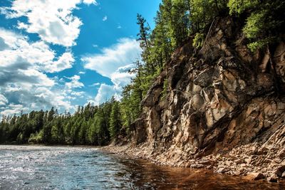 Scenic view of waterfall in forest against sky