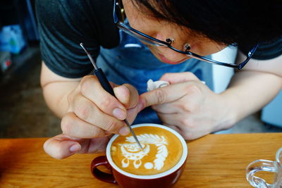 Midsection of woman holding coffee cup on table